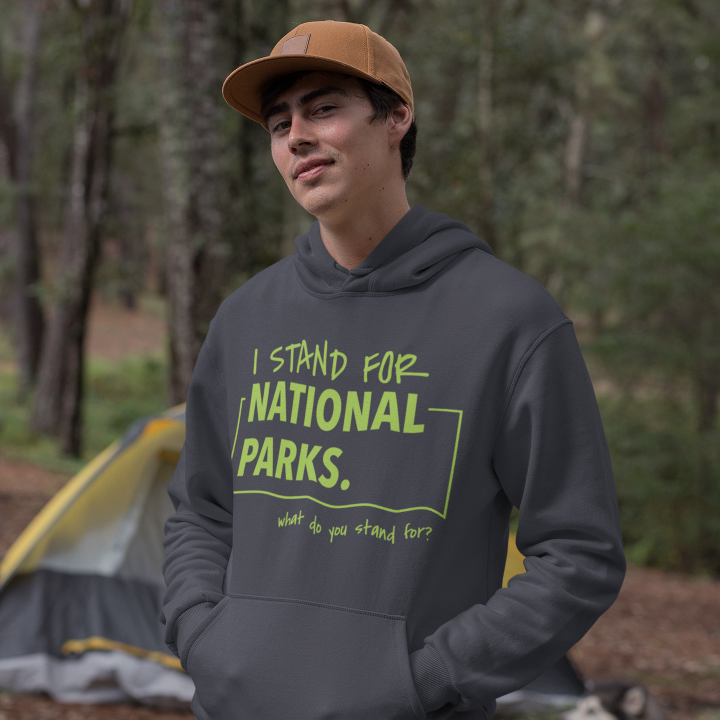 Person wearing a hoodie with 'I stand for National Parks' text in a forest setting.