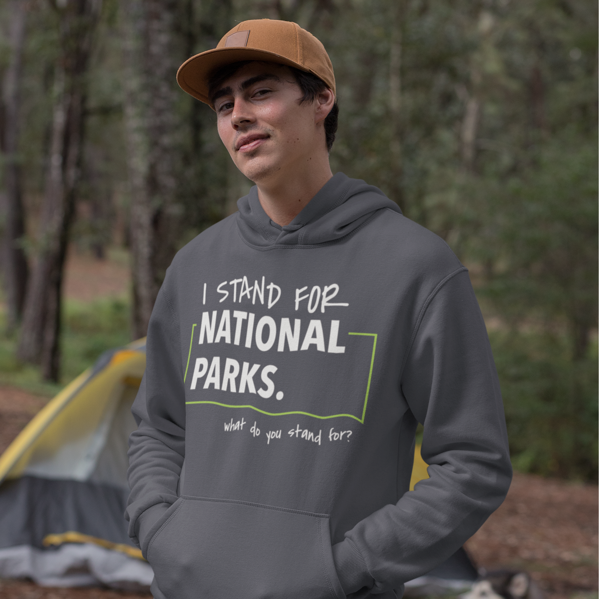 Person wearing a hoodie with 'I stand for National Parks' text in a forest setting.