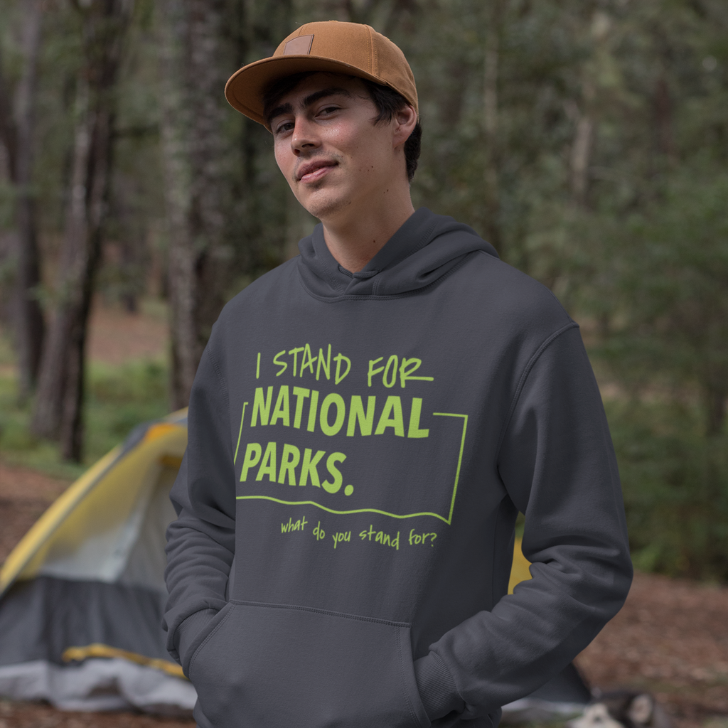 Person wearing a hoodie with 'I stand for National Parks' text in a forest setting.