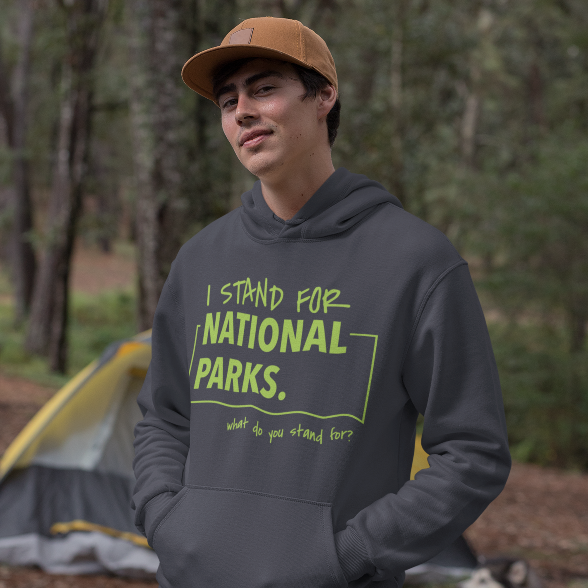 Person wearing a hoodie with 'I stand for National Parks' text in a forest setting.