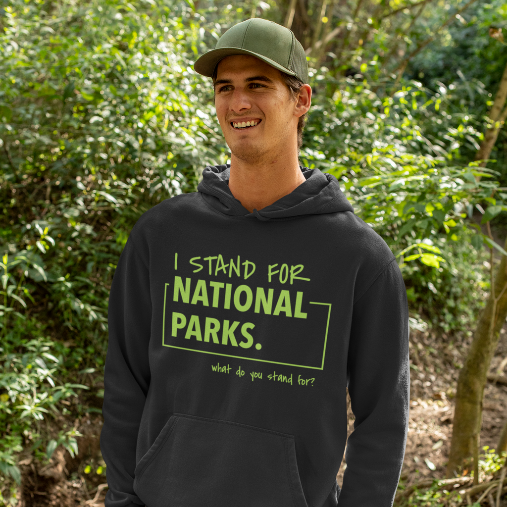 Person wearing a hoodie with 'I stand for National Parks' text in a forest setting