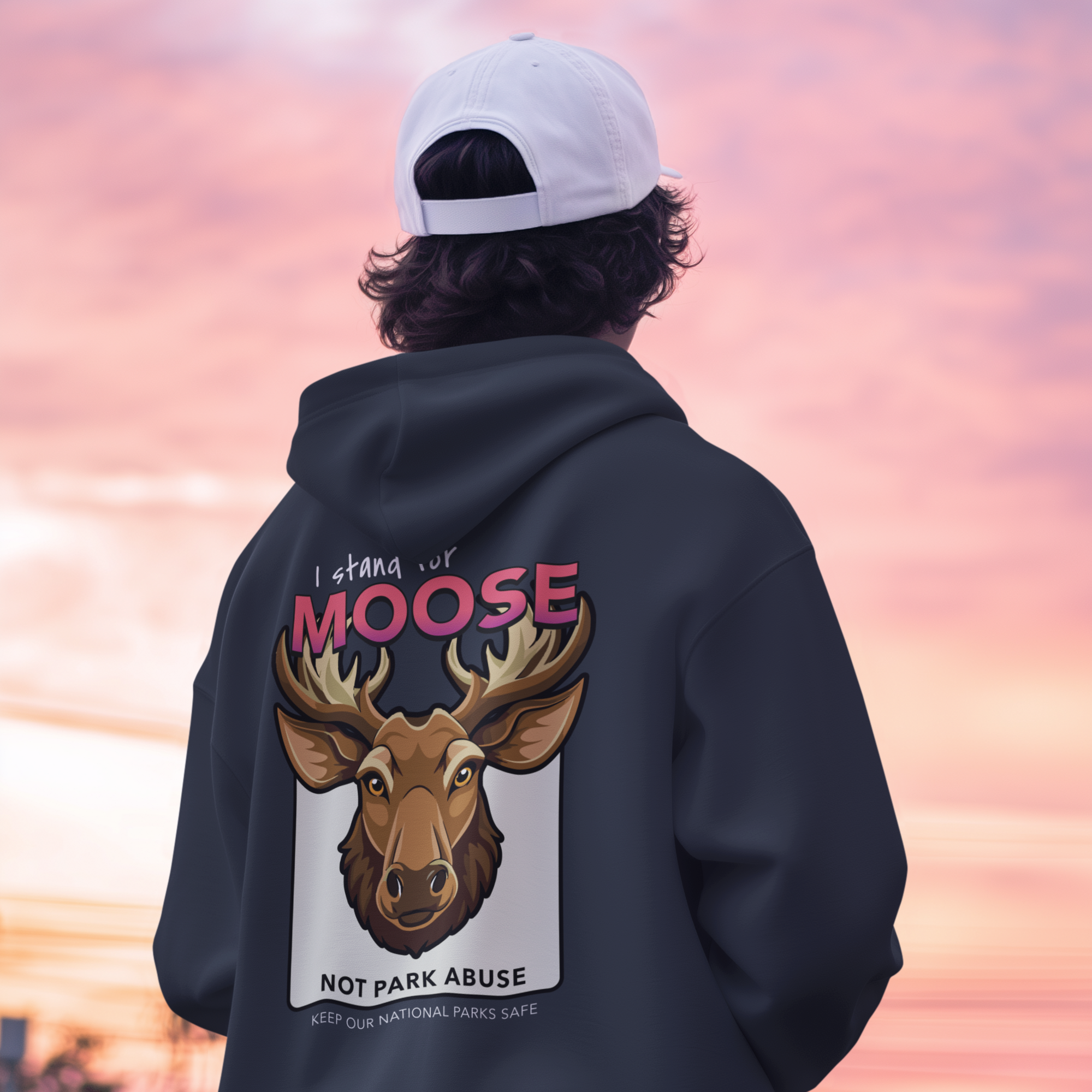 Person wearing a hoodie with a moose graphic and text, standing against a colorful sky.